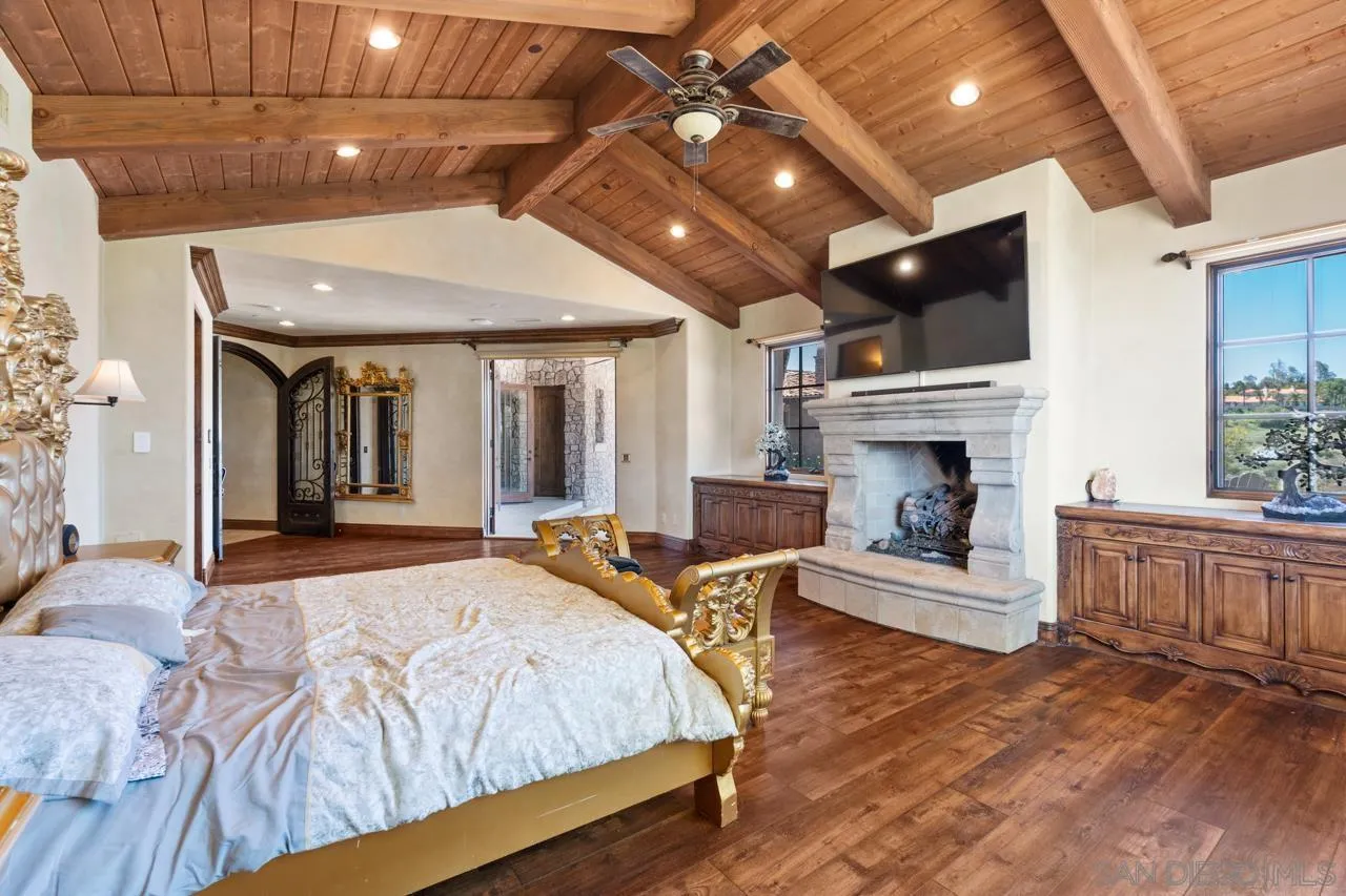 19612 Rangeland Road Ramona, CA 92065 - Photo 44 of 65 a spacious bedroom with a bed and a fireplace