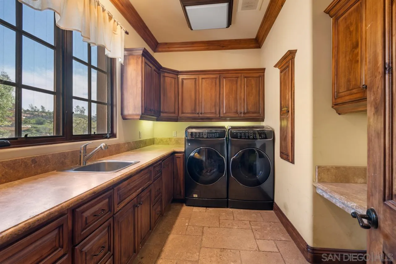 19612 Rangeland Road Ramona, CA 92065 - Photo 56 of 65 a utility room with a sink a washer and dryer next to a window