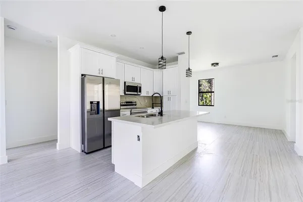 a kitchen with stainless steel appliances a refrigerator sink and microwave