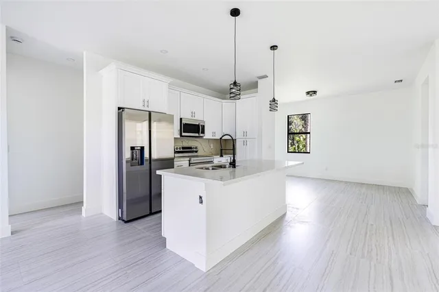 a kitchen with stainless steel appliances a refrigerator sink and microwave