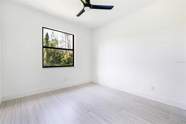 an empty room with wooden floor cabinet and windows