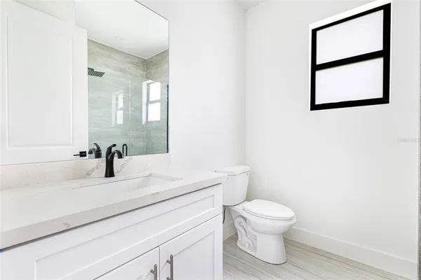 a bathroom with a toilet a sink and a mirror