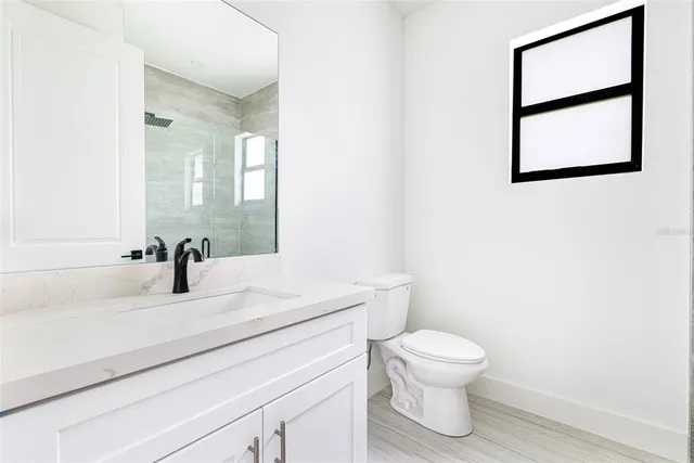 a bathroom with a toilet a sink and a mirror