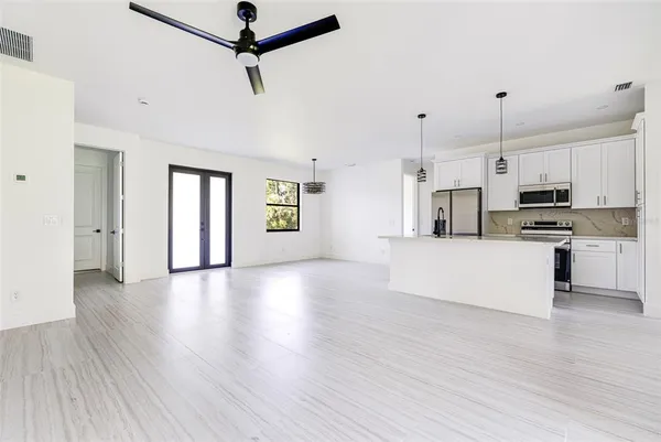 a view of kitchen with stainless steel appliances refrigerator stove microwave and cabinets