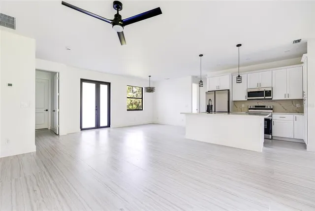 a view of kitchen with stainless steel appliances refrigerator stove microwave and cabinets