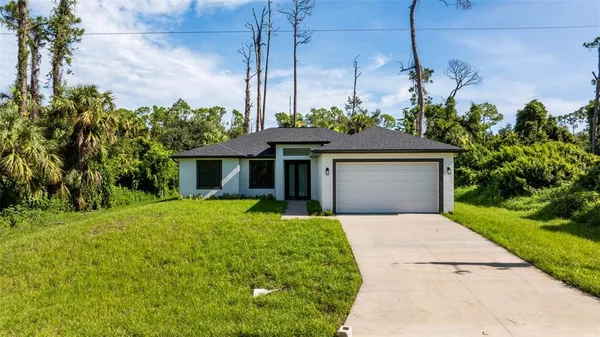 an aerial view of a house with garden space and trees all around