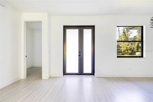 an empty room with wooden floor and windows