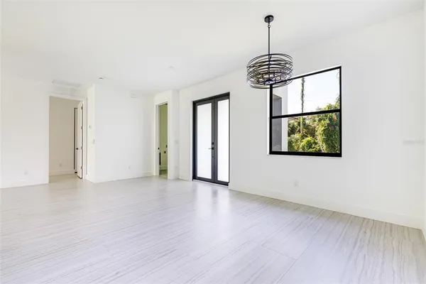 a view of an empty room with window and wooden floor
