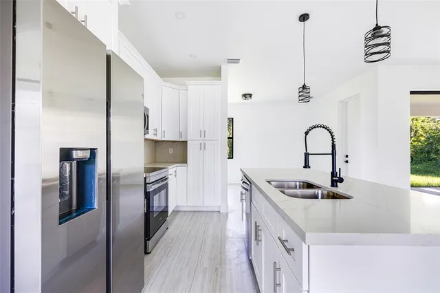 a kitchen with kitchen island stainless steel appliances a sink stove and refrigerator