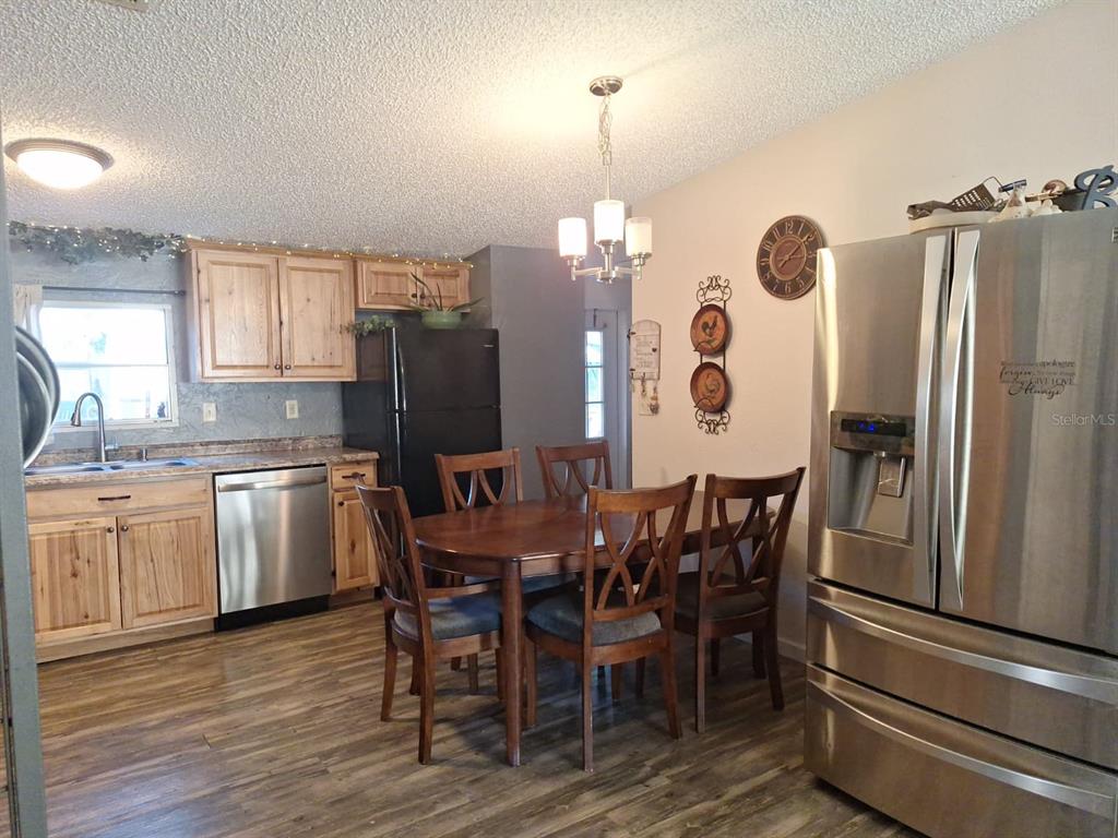 14899 Southwest 92nd Way Lake Butler, FL 32054 - Photo 12 of 39 a kitchen with stainless steel appliances a dining table chairs stove refrigerator and microwave