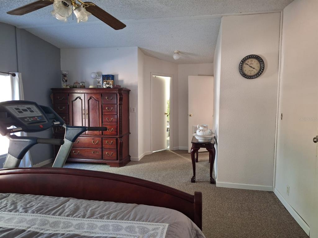 14899 Southwest 92nd Way Lake Butler, FL 32054 - Photo 16 of 39 a bedroom with a bed and a chandelier