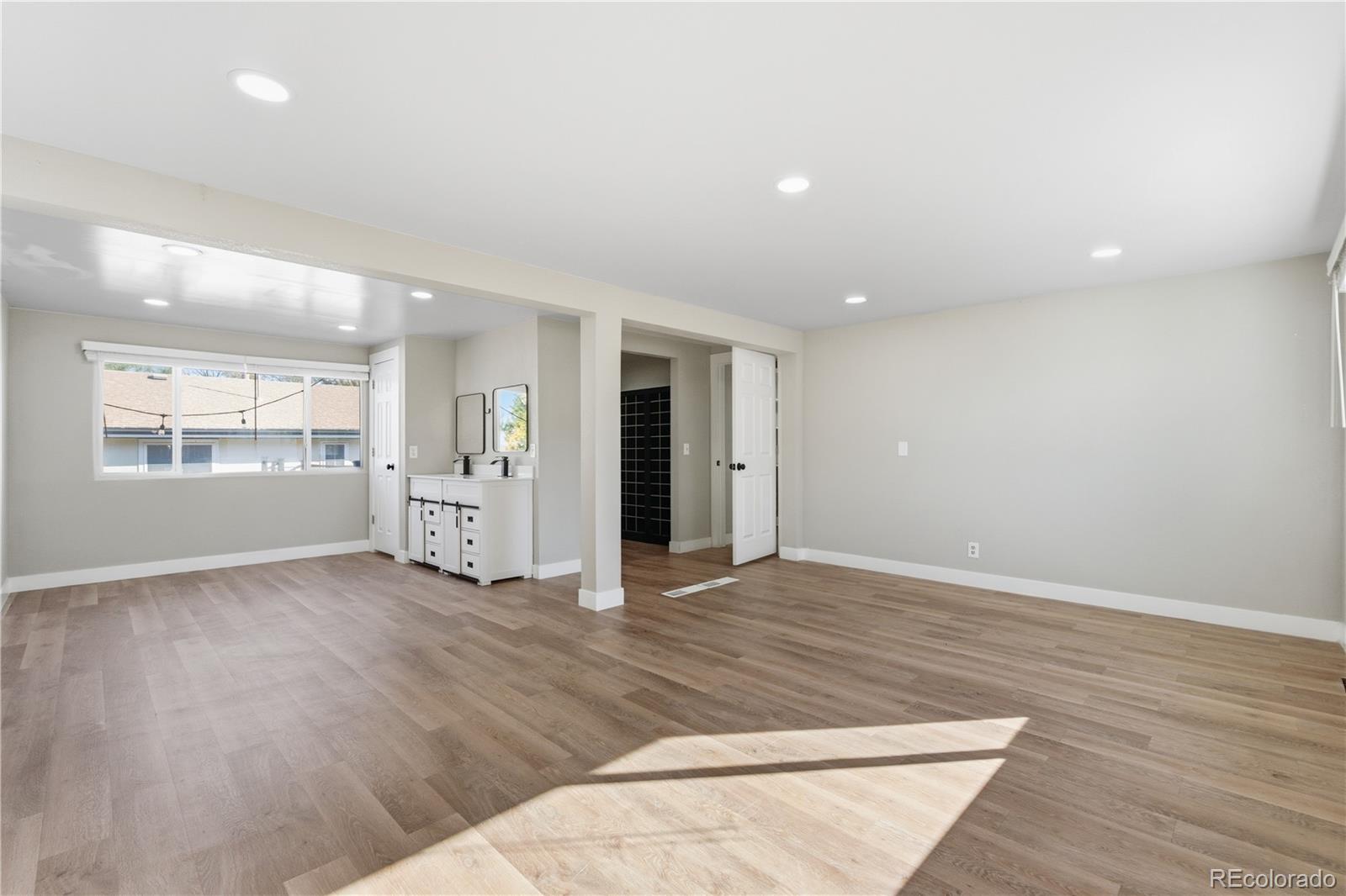 610 6th Street Bennett, CO 80102 - Photo 6 of 8 an empty room with wooden floor and windows