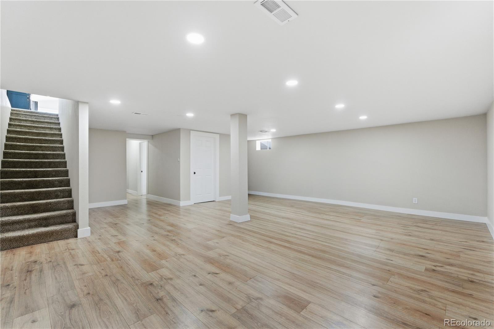 610 6th Street Bennett, CO 80102 - Photo 7 of 8 an empty room with wooden floor and windows