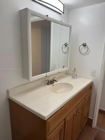 a bathroom with a sink vanity and a mirror