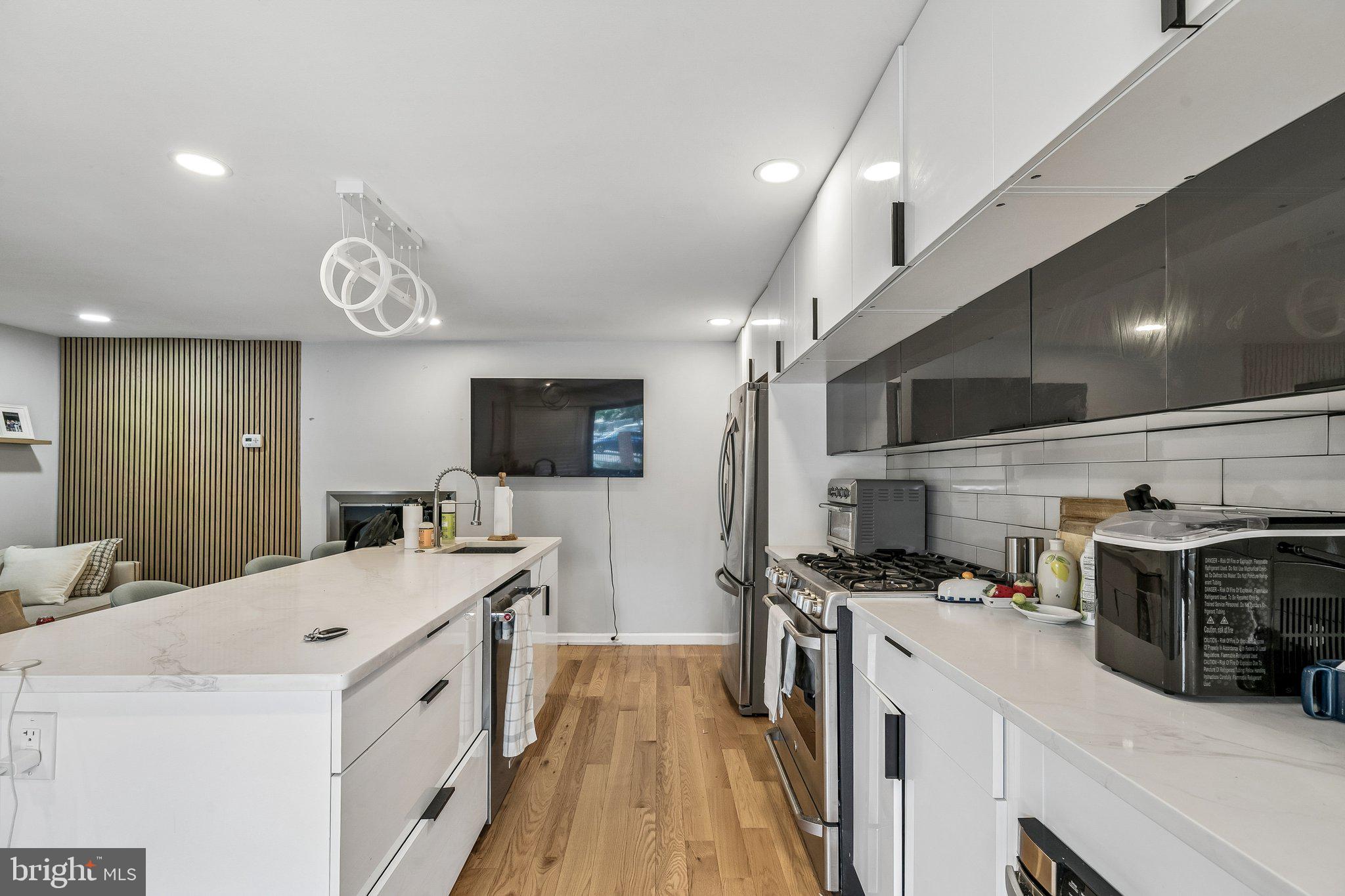 1130 Lombard Street Philadelphia, PA 19147 - Photo 10 of 45 a kitchen with stainless steel appliances a stove top oven a sink dishwasher and a refrigerator with wooden floor