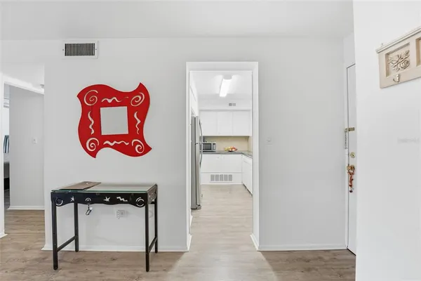a hallway with a table and a painting on the wall