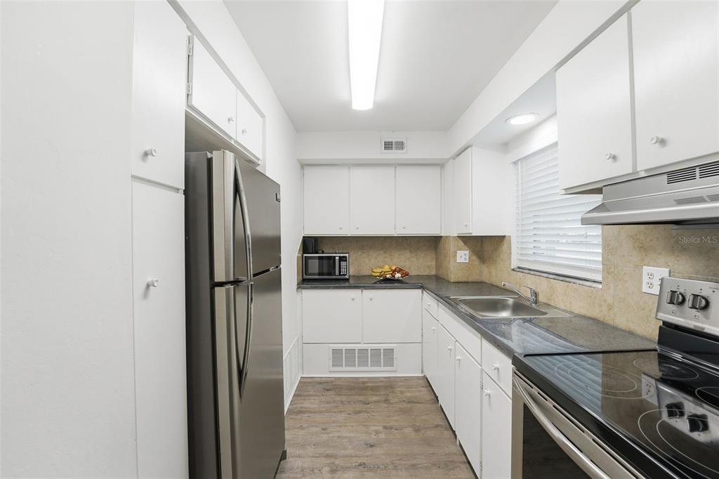 3900 Roxane Boulevard, Unit 10A Sarasota, FL 34235 - Photo 17 of 30 a kitchen with a sink a refrigerator and cabinets