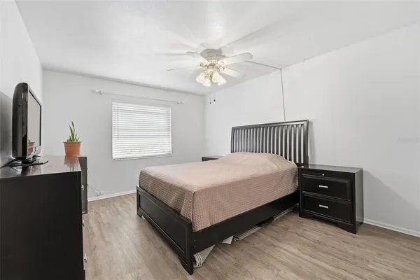 a bedroom with a bed and a flat tv screen on a dresser