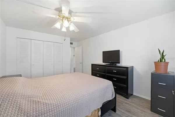 a bedroom with a bed and a flat tv screen on dresser