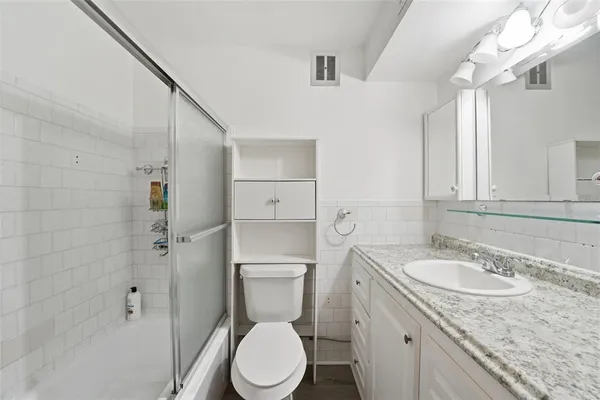 a bathroom with a granite countertop sink toilet and shower