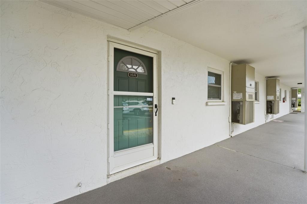 3900 Roxane Boulevard, Unit 10A Sarasota, FL 34235 - Photo 23 of 30 a view of a hallway with wooden floor and a living room