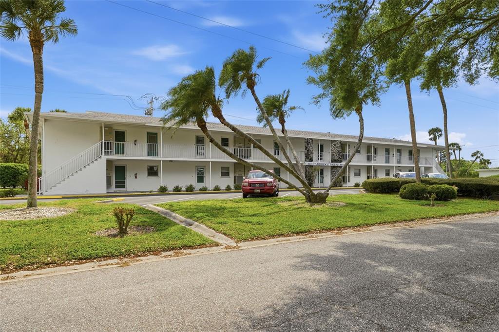 3900 Roxane Boulevard, Unit 10A Sarasota, FL 34235 - Photo 10 of 30 a view of a house with a yard and palm trees