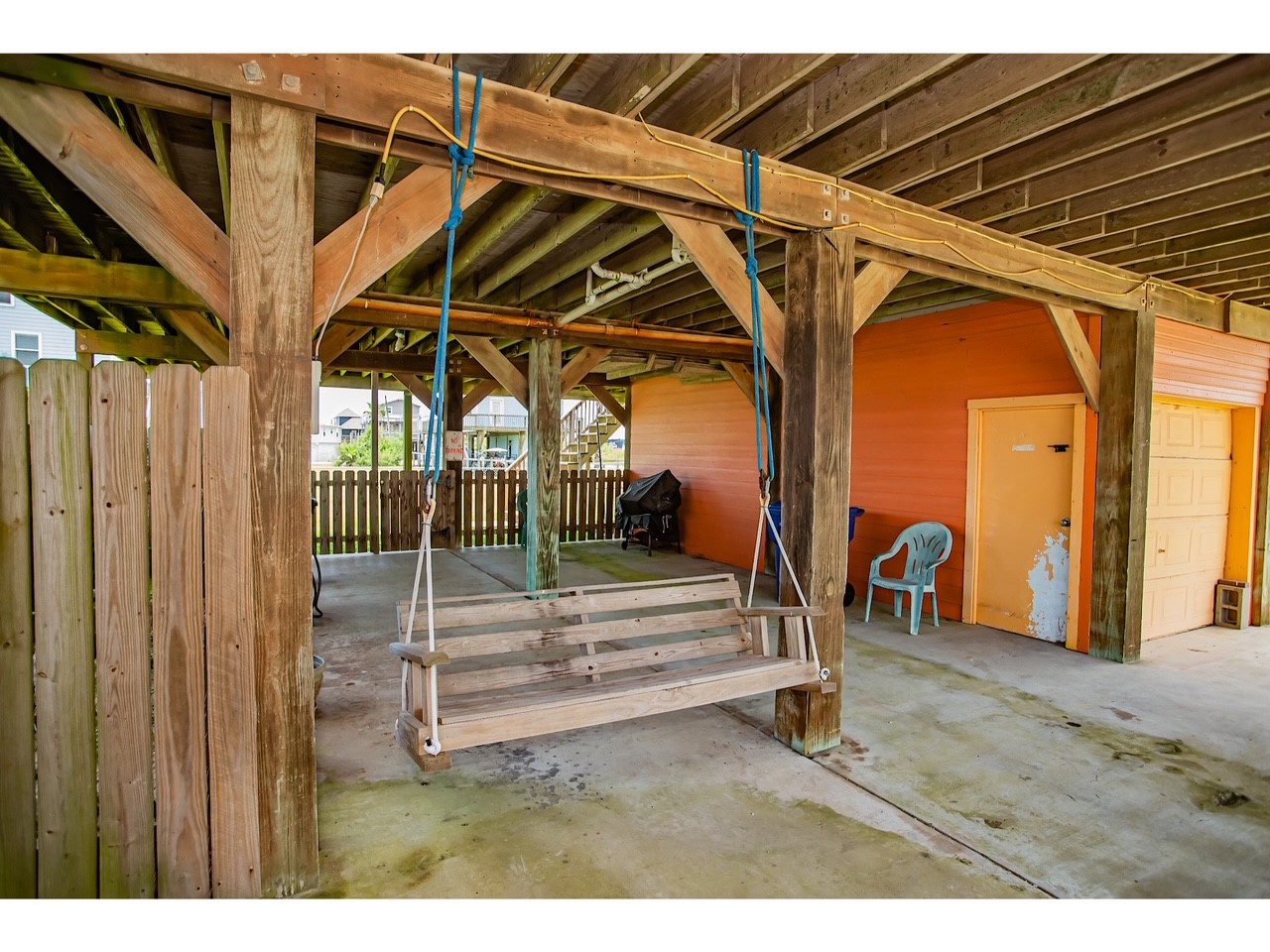 419 Thunder Road Surfside Beach, TX 77541 - Photo 24 of 32 Spacious covered area perfect for relaxation and entertainment, featuring a charming swing and ample seating. Ideal for family gatherings or quiet retreats.