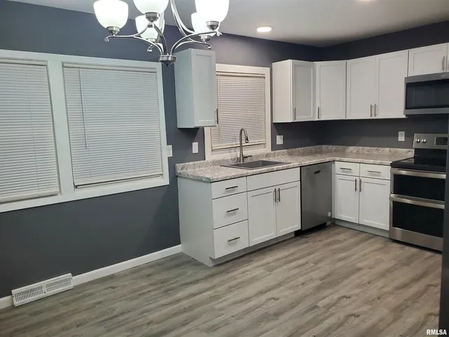 a kitchen with stainless steel appliances granite countertop a sink a stove a refrigerator and cabinets