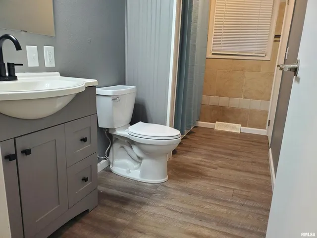 a bathroom with a toilet sink and shower