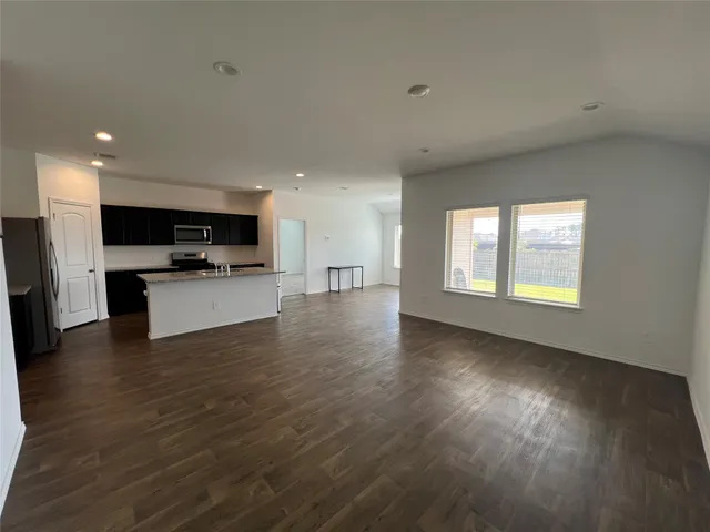 a view of kitchen with microwave a stove and wooden floor