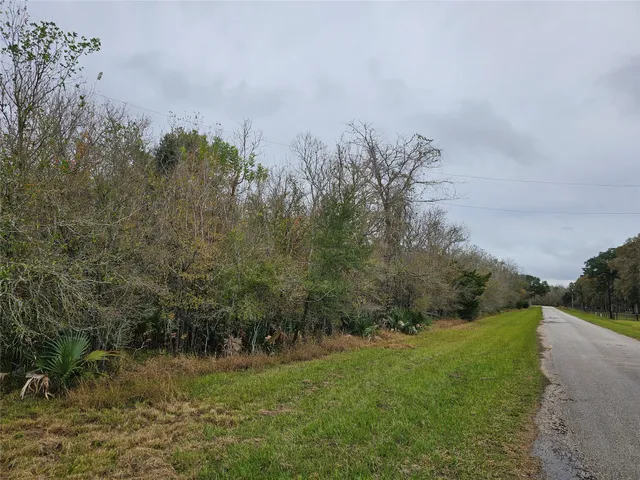 a view of a lake with a yard and large trees