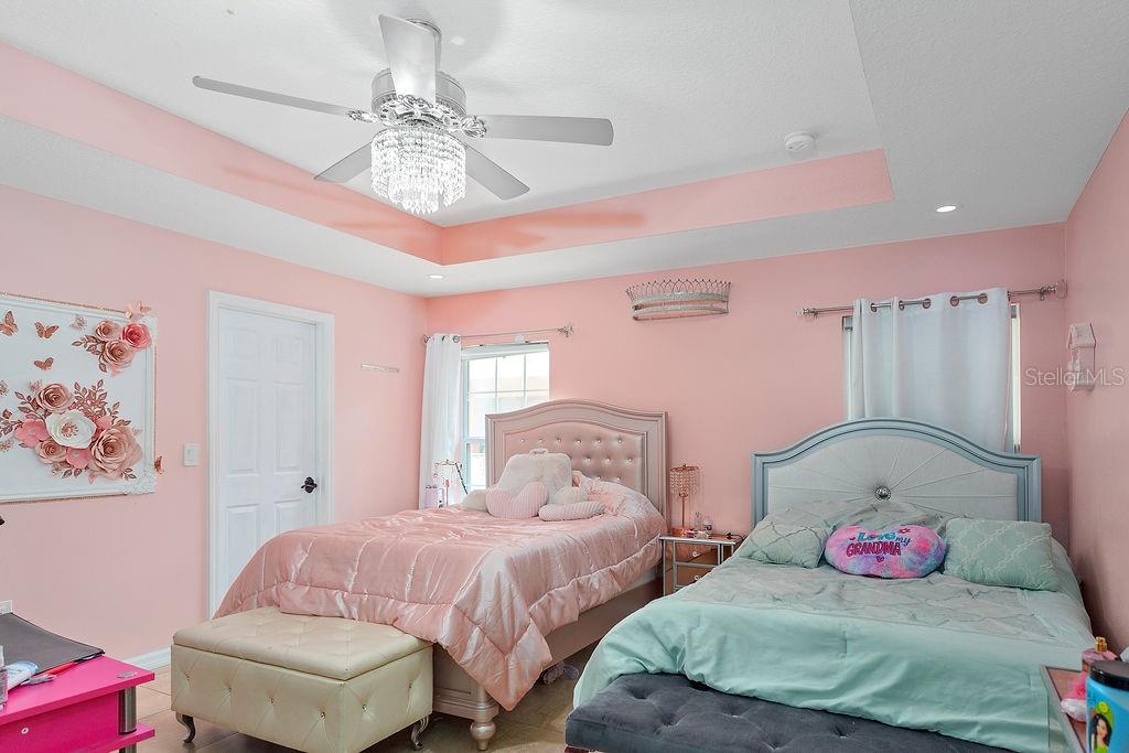 4907 Carlyle Road Tampa, FL 33615 - Photo 17 of 29 a bedroom with two beds and a chandelier