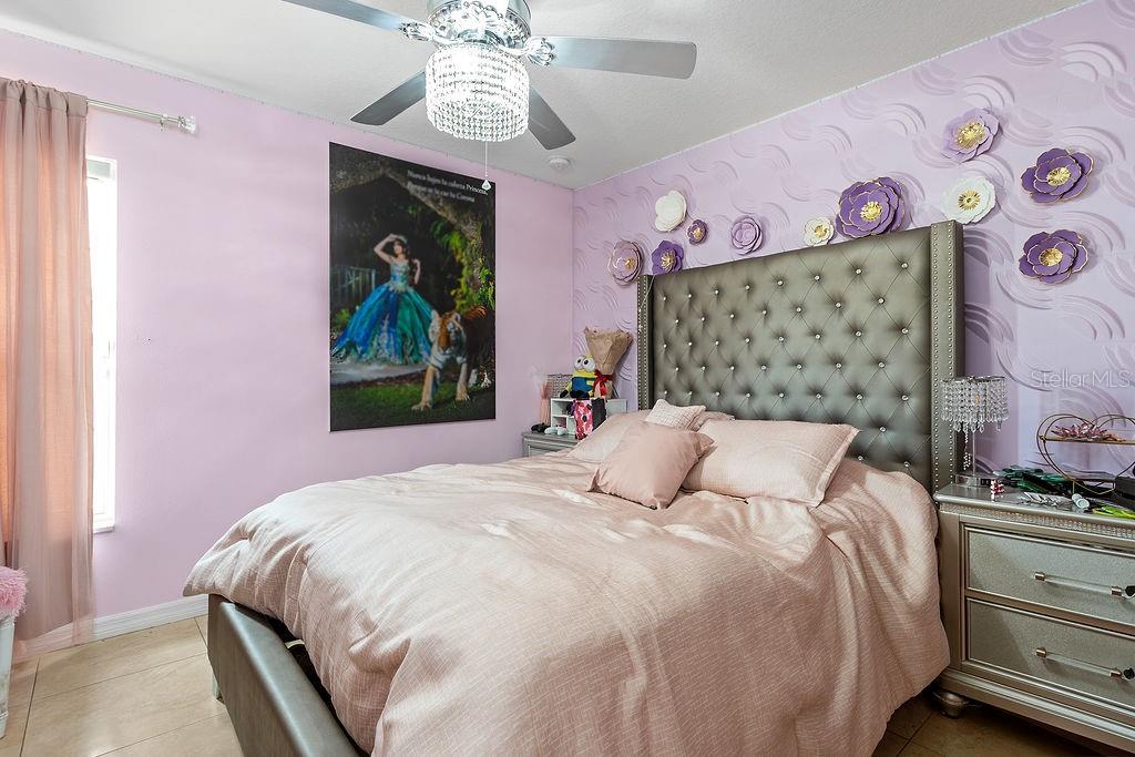 4907 Carlyle Road Tampa, FL 33615 - Photo 19 of 29 a bedroom with a bed and a chandelier