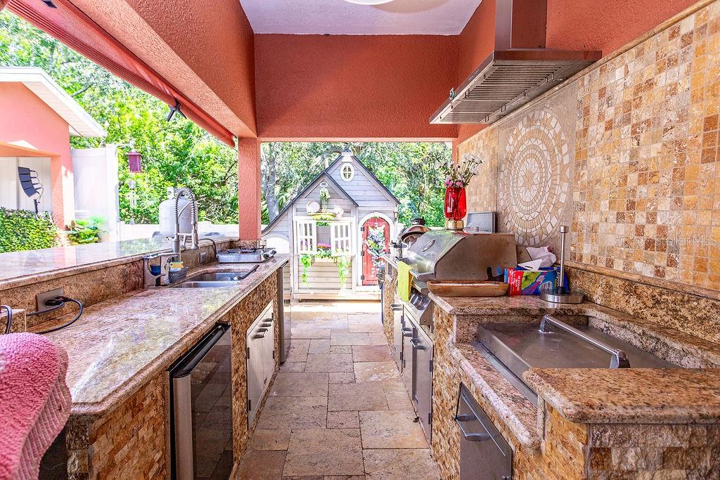 4907 Carlyle Road Tampa, FL 33615 - Photo 27 of 29 a open kitchen with stainless steel appliances granite countertop a barbecue grill and a couches next to a yard