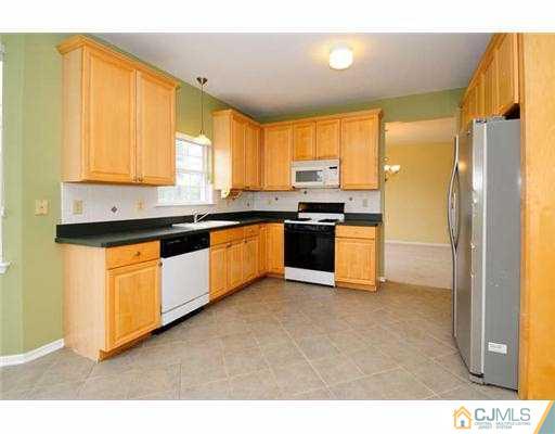 34 Lexington Road Monmouth Junction, NJ 08852 - Photo 4 of 17 a kitchen with stainless steel appliances granite countertop a stove a sink and a refrigerator