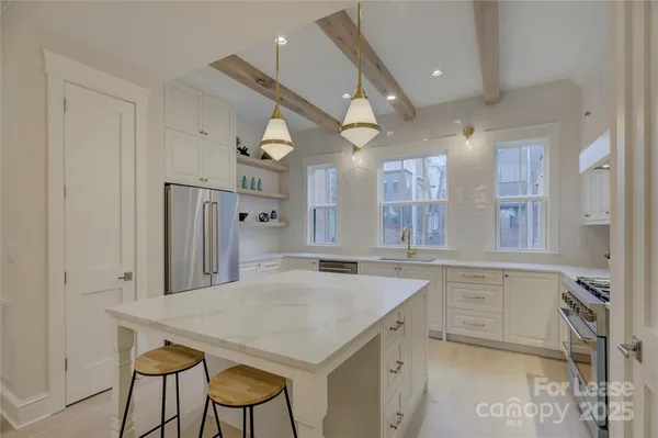 a kitchen with a table chairs refrigerator and cabinets