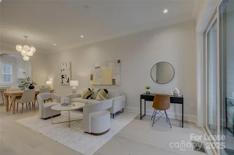 a living room with couches and kitchen view with wooden floor