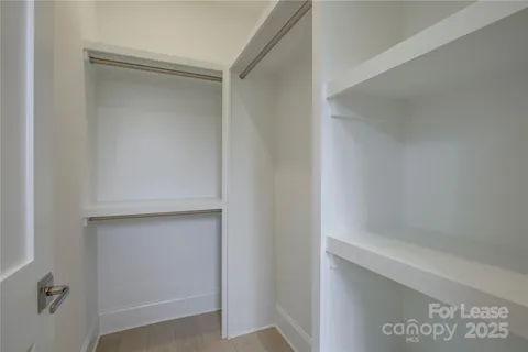 a bedroom with a large bed and a potted plant