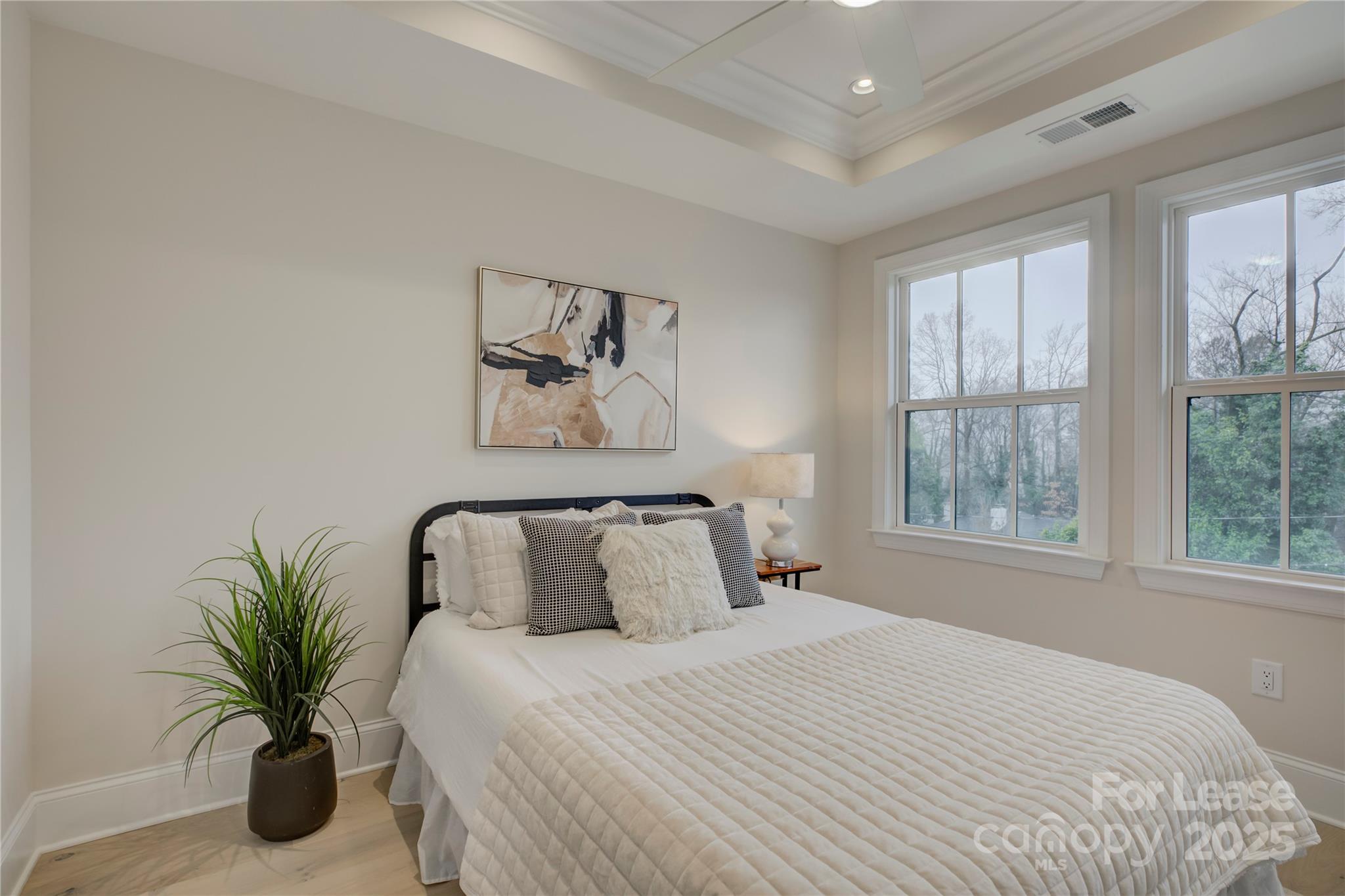 3015 Pinehurst Place Charlotte, NC 28209 - Photo 19 of 31 a bedroom with a large bed and a potted plant