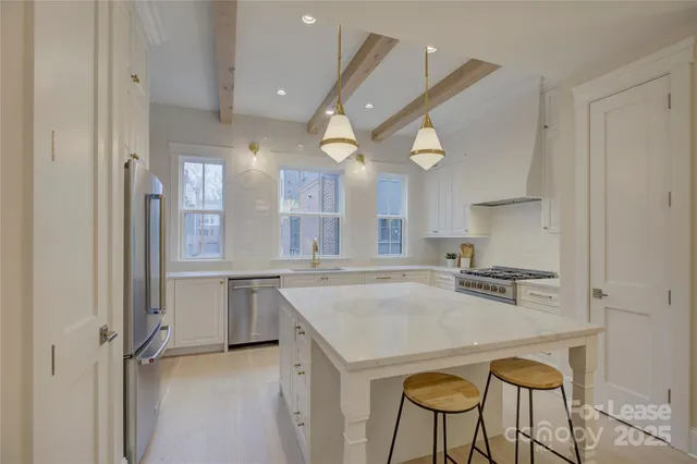 a kitchen with stainless steel appliances granite countertop a stove a sink and a refrigerator