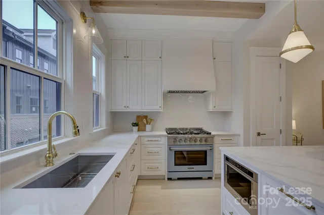 a kitchen with granite countertop a stove sink and cabinets