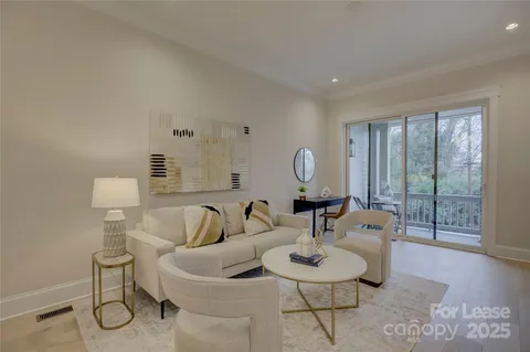 a living room with furniture a mirror and wooden floor