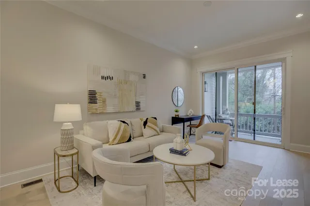 a living room with furniture a mirror and wooden floor