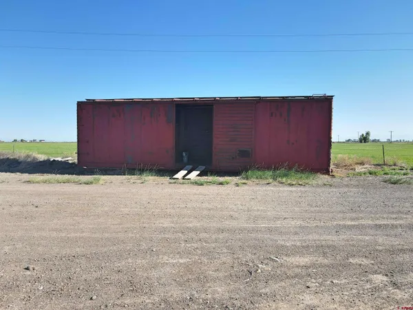 a wooden building with a field