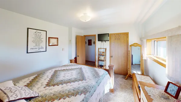 a bedroom with a bed and a dresser with rug