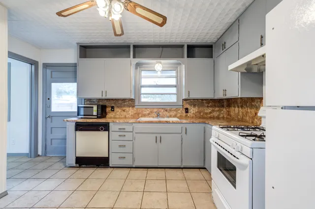 a kitchen with a stove sink and cabinets