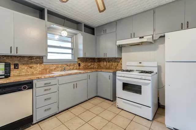 a kitchen with granite countertop cabinets and white appliances
