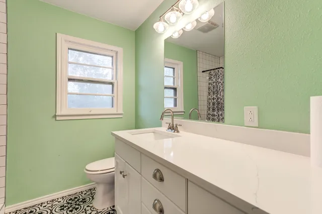 a bathroom with a sink a toilet and a mirror