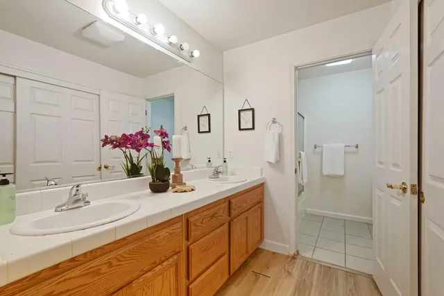 a bathroom with a sink double vanity granite tub and shower