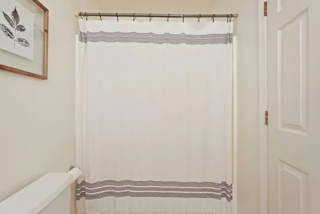 a bathroom with a shower curtain and a window